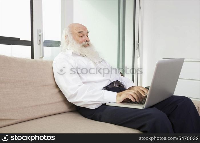 Senior man reading newspaper in house