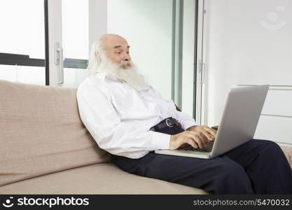 Senior man reading newspaper in house