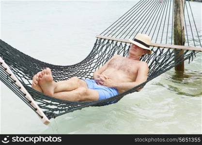 Senior Man Relaxing In Beach Hammock