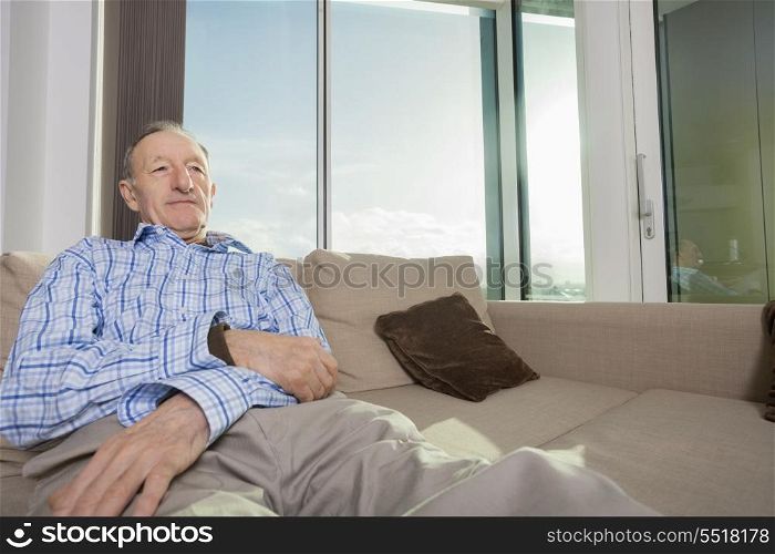 Senior man relaxing on sofa at home
