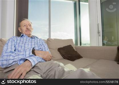 Senior man relaxing on sofa at home