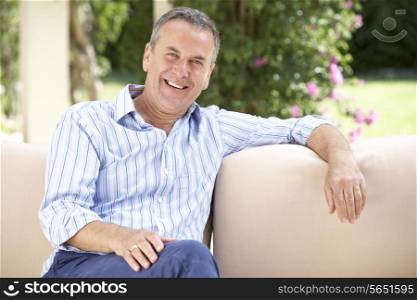 Senior Man Relaxing On Sofa At Home