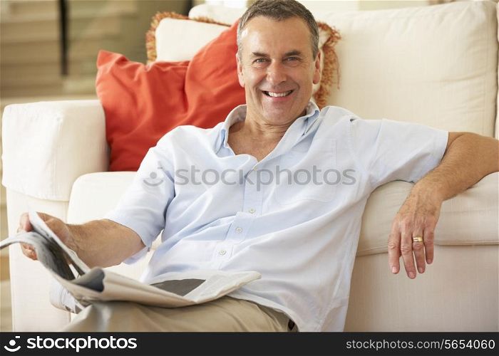 Senior Man Relaxing On Sofa At Home Reading Newspaper