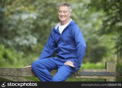 Senior Man Resting Whilst Exercising In Countryside