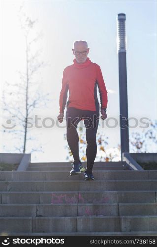 Senior man running downstairs sunlight effect in the park