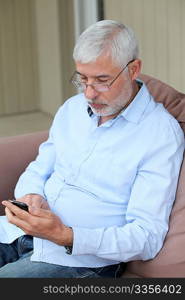 Senior man sending message with mobile phone