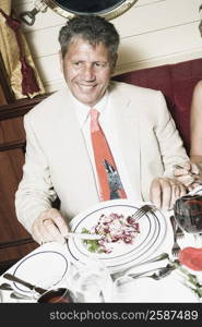 Senior man sitting at a table and taking food