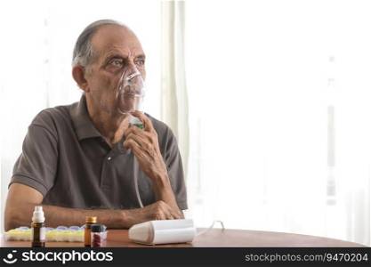 Senior man sitting at table with an oxygen mask.  Health and medicine  