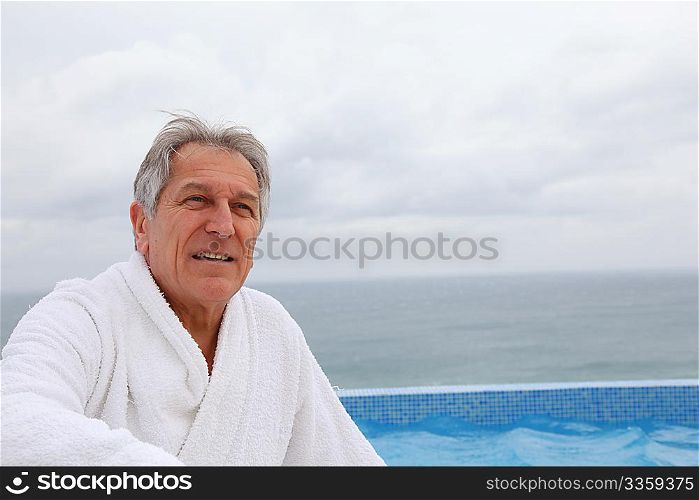 Senior man sitting by pool