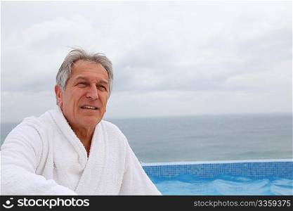 Senior man sitting by pool