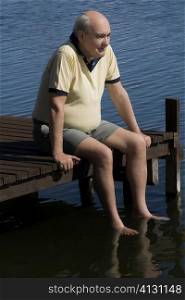 Senior man sitting on a boardwalk