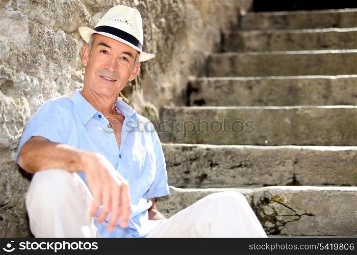 Senior man sitting on some old stone steps