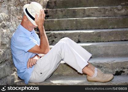 Senior man sitting on some stone steps