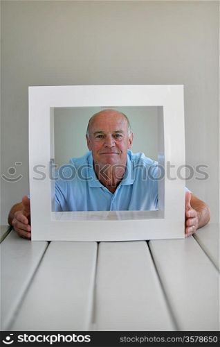 Senior man sitting with a white frame
