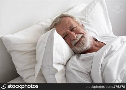 senior man sleep with smile on bed in room