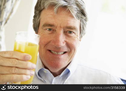 Senior Man Smiling At Camera And Drinking Orange Juice