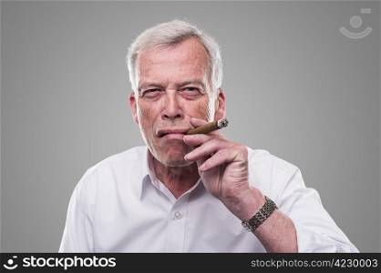 Senior man smoking a cigar. Strong personality.