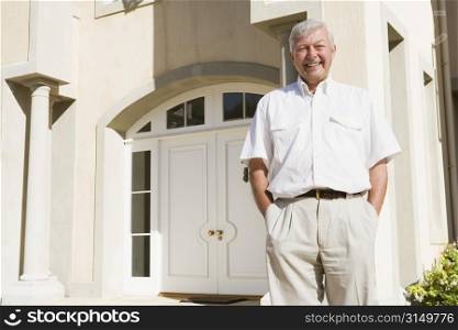 Senior man standing outside his home