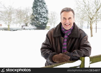 Senior Man Standing Outside In Snowy Landscape