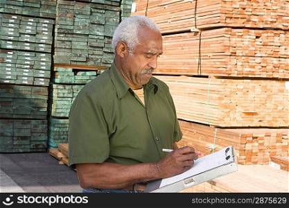 Senior man stock-taking in warehouse