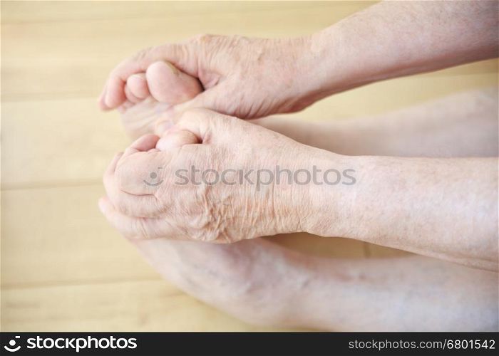 Senior man stretches, and holds his toes.