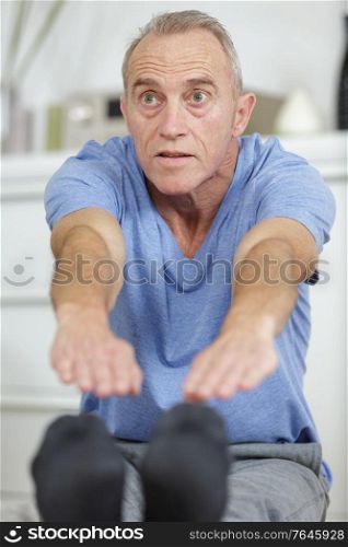 senior man stretching his legs during rehabilitation