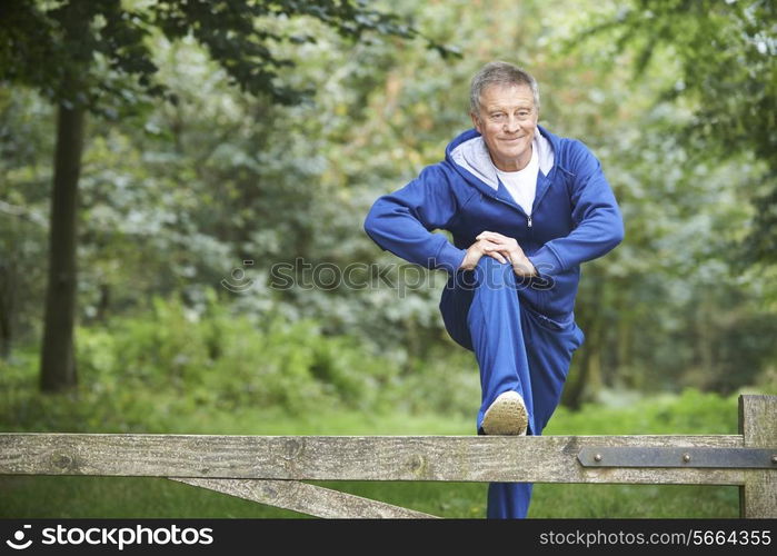 Senior Man Stretching On Countryside Run