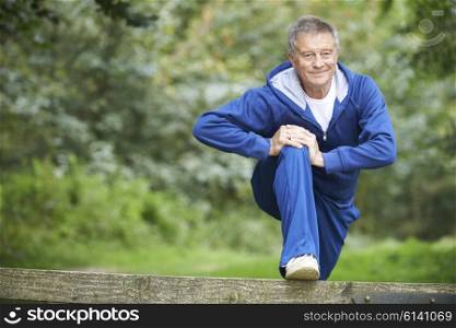 Senior Man Stretching On Countryside Run