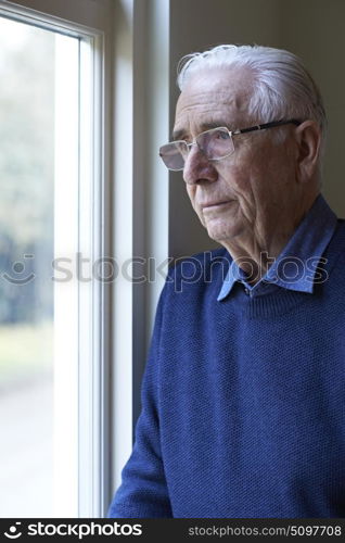 Senior Man Suffering From Depression Looking Out Of Window