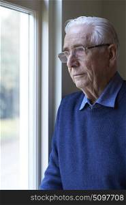 Senior Man Suffering From Depression Looking Out Of Window