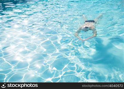 Senior man swimming in outdoor swimming pool