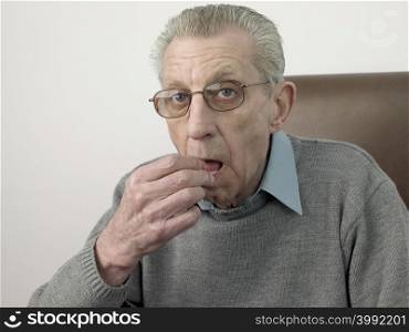 Senior man taking a tablet