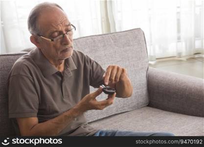 Senior man taking his diabetes test at home. (Health and fitness) 