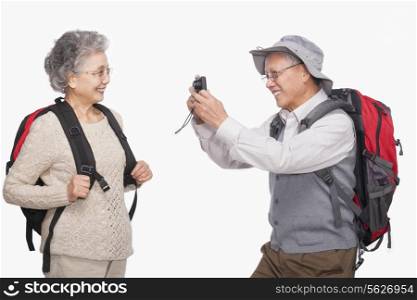 Senior man taking wife&rsquo;s picture with digital camera