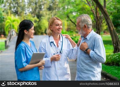 Senior man talking to doctor, nurse or caregiver in the park. Mature people healthcare and medical staff service concept.