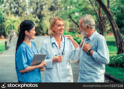 Senior man talking to doctor, nurse or caregiver in the park. Mature people healthcare and medical staff service concept.. Senior couple talking to nurse or caregiver.