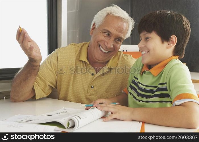 Senior man teaching his grandson and smiling