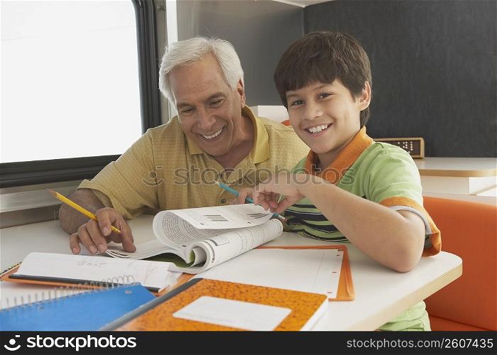Senior man teaching his grandson and smiling