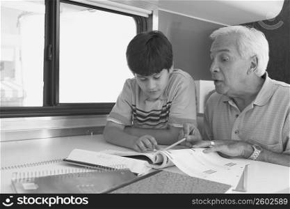 Senior man teaching his grandson in a motor home