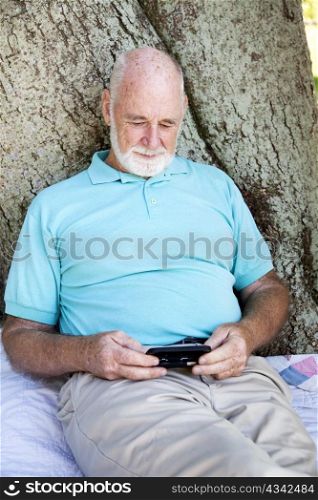 Senior man texting on his smart phone.