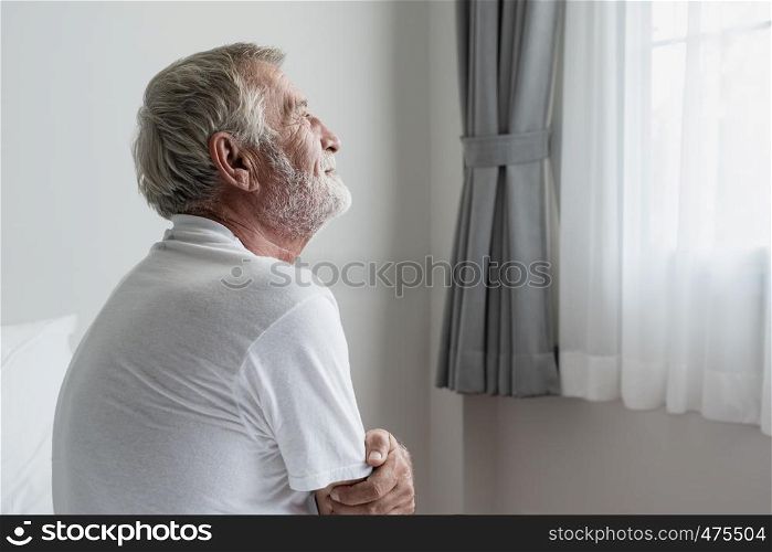 senior man thinking or try to remember alone on bed in white room