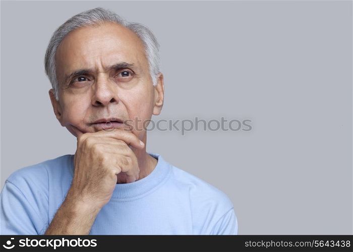 Senior man thinking with hand on chin