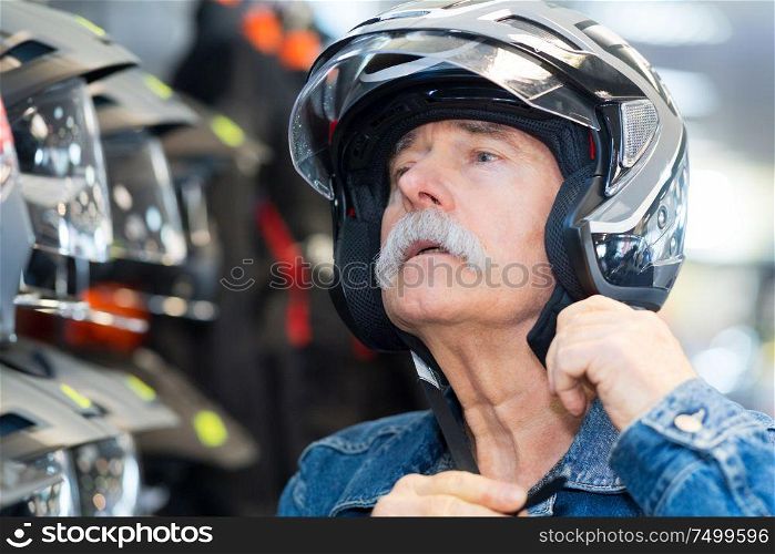 senior man trying on a crash helmet