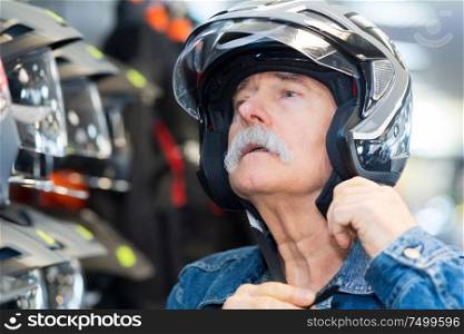 senior man trying on a crash helmet