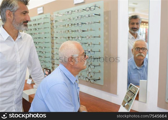 senior man trying on optical glasses