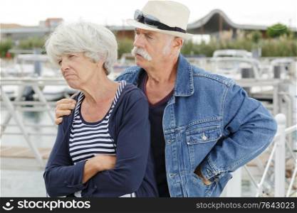 senior man trying to console grumpy wife