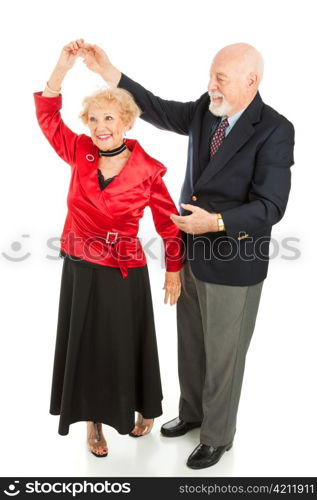 Senior man twirls his wife as they dance together. Full body isolated on white.