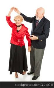 Senior man twirls his wife as they dance together. Full body isolated on white.