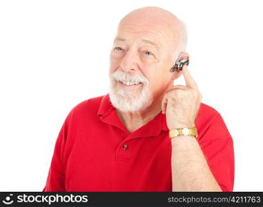 Senior man using a hands-free mobile phone ear piece. Isolated on white.