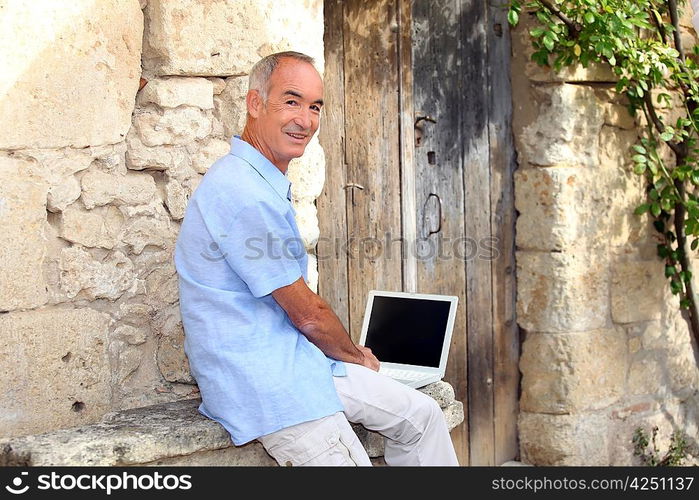 Senior man using a laptop with a blank screen